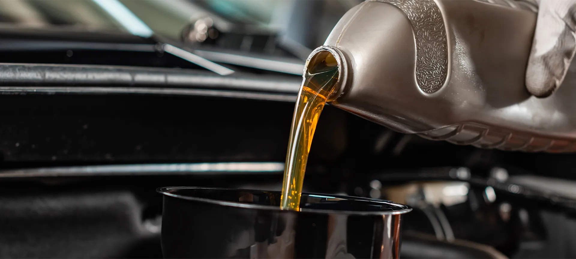 Golden engine oil being poured into an engine