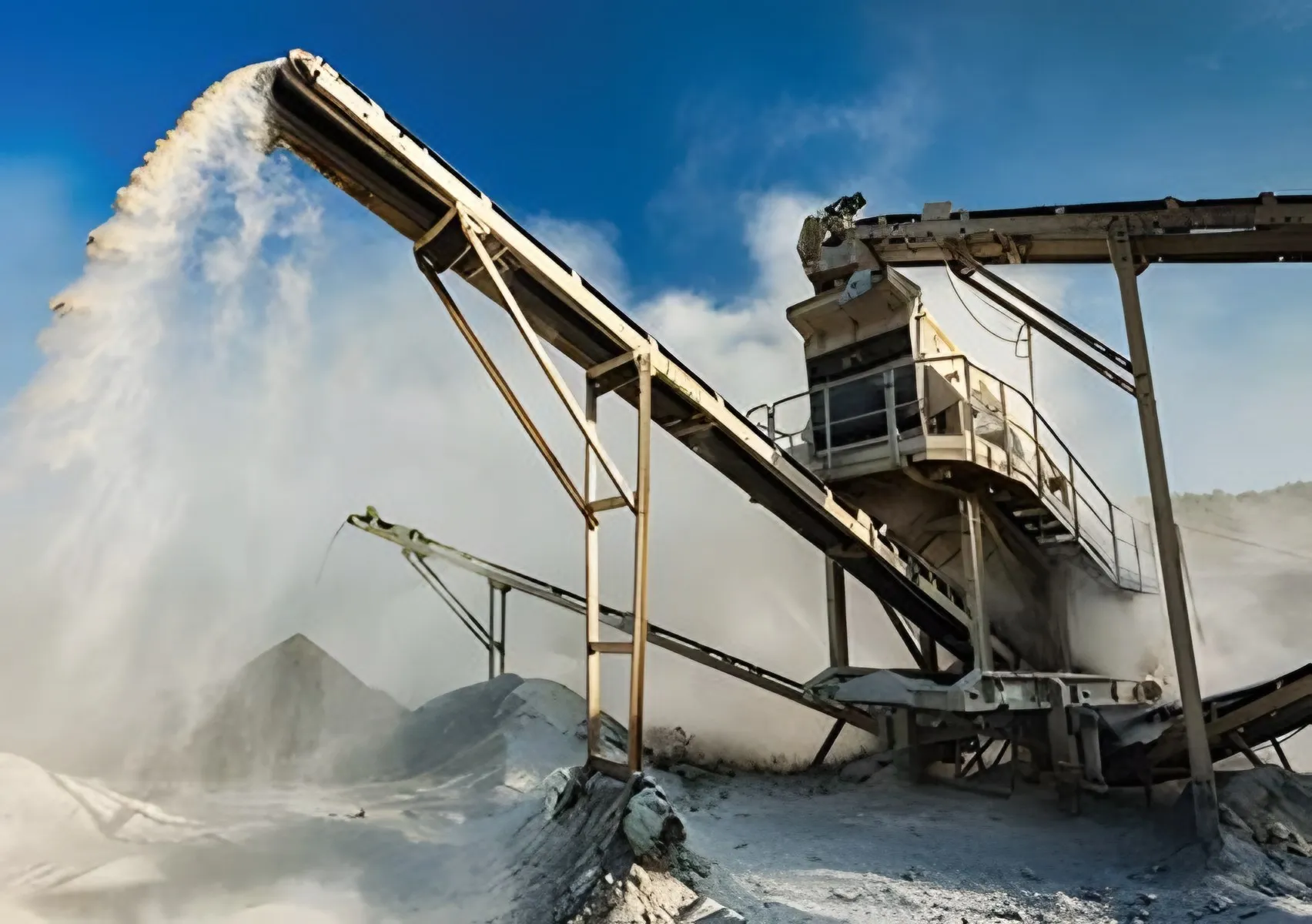 Dust rising from a conveyor stockpile at a mine